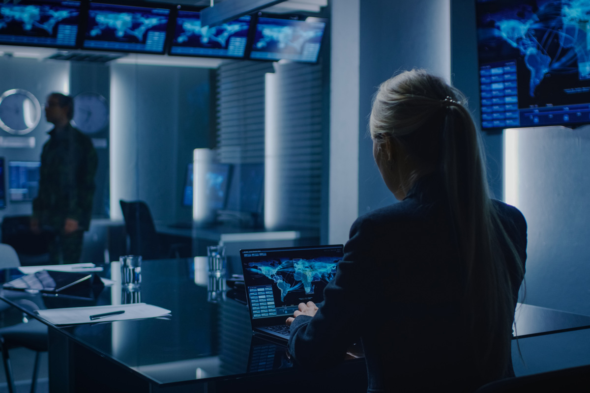woman working in a dim room on a laptop